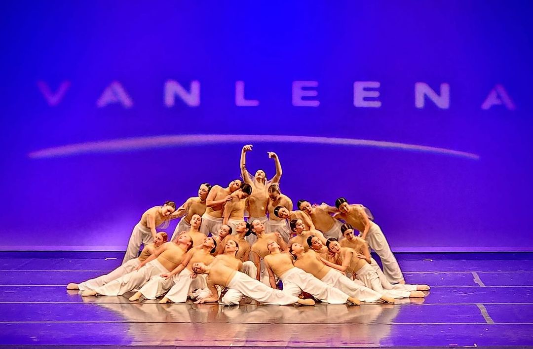 A group of ballerinas gracefully performing on stage, showcasing their elegant dance moves and synchronized choreography.