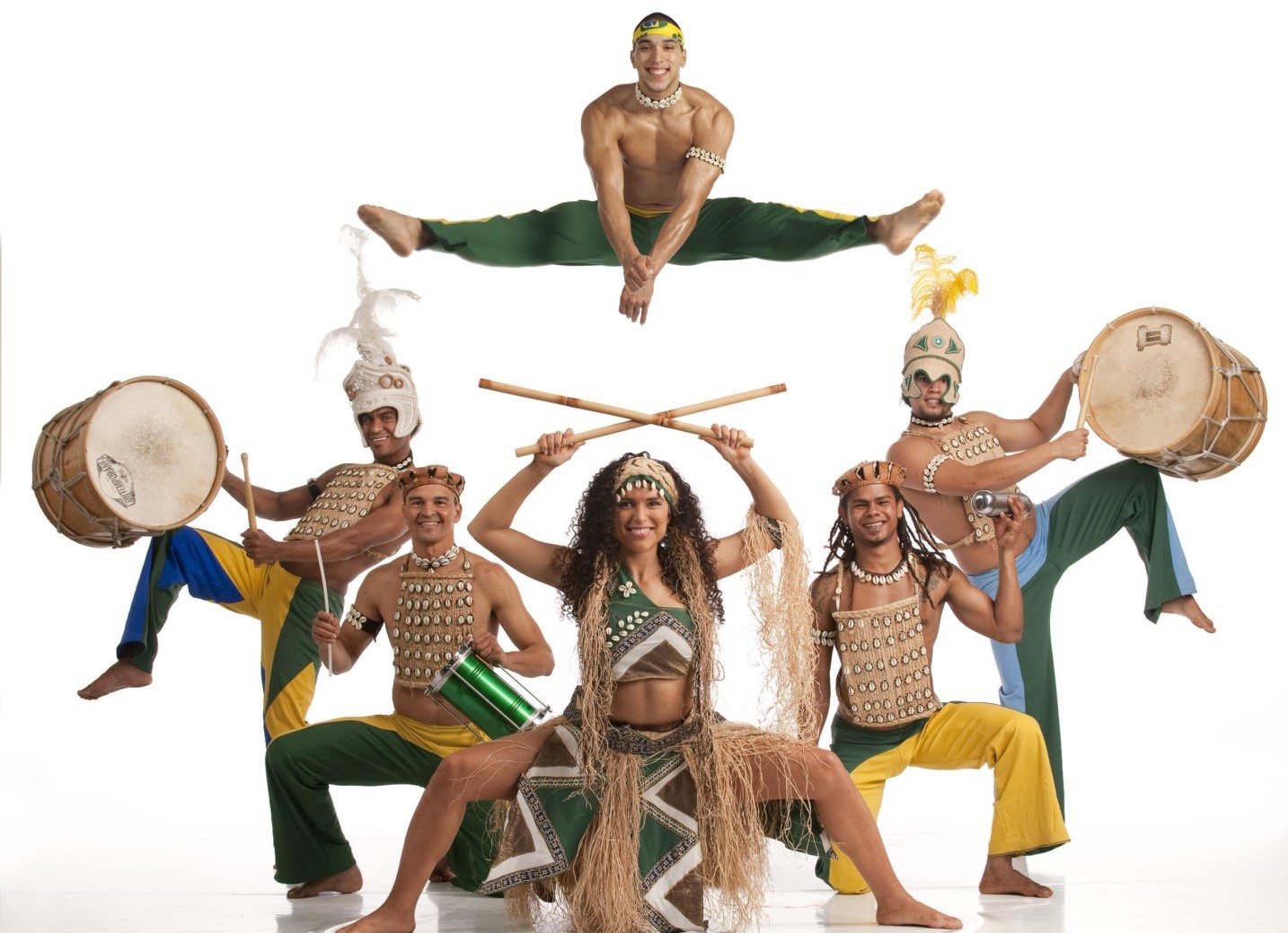 The image shows a group of people wearing Brazilian traditional costumes as part of a performance by Aché Brasil. The group combines music, dance, and Capoeira to create a vibrant and energetic show.